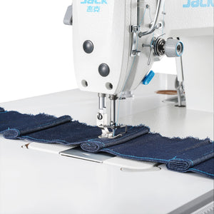 JACK A2C-C High-Speed Single Needle Sewing machine stitching blue denim fabric on a white background