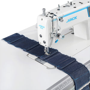 JACK A2C-C High-Speed Single Needle sewing machine stitching blue denim fabric on a white background